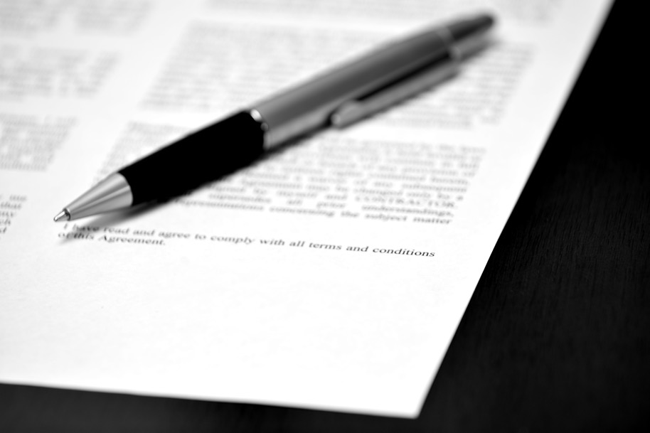 Stift auf Vertragspapier mit leerer Zeile zur Unterschrift, um die Vereinbarung zu schließen